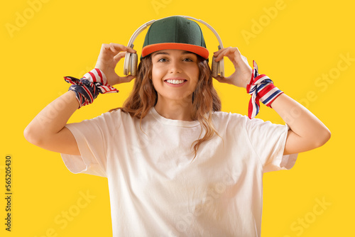 Female hip-hop dancer with headphones on yellow background
