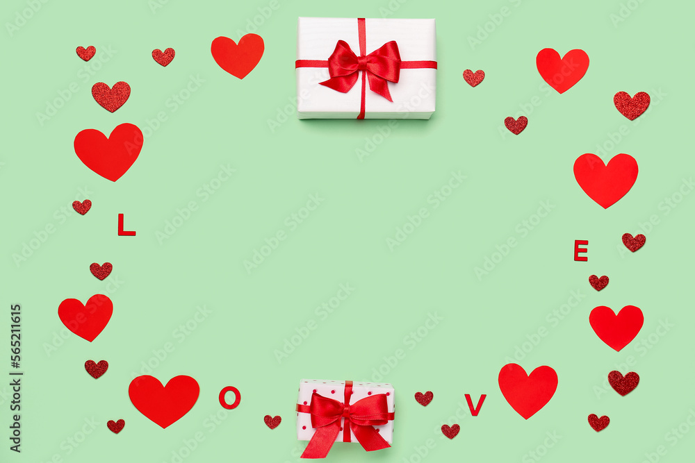 Frame made of gift boxes and paper hearts on green background. Valentine's Day celebration