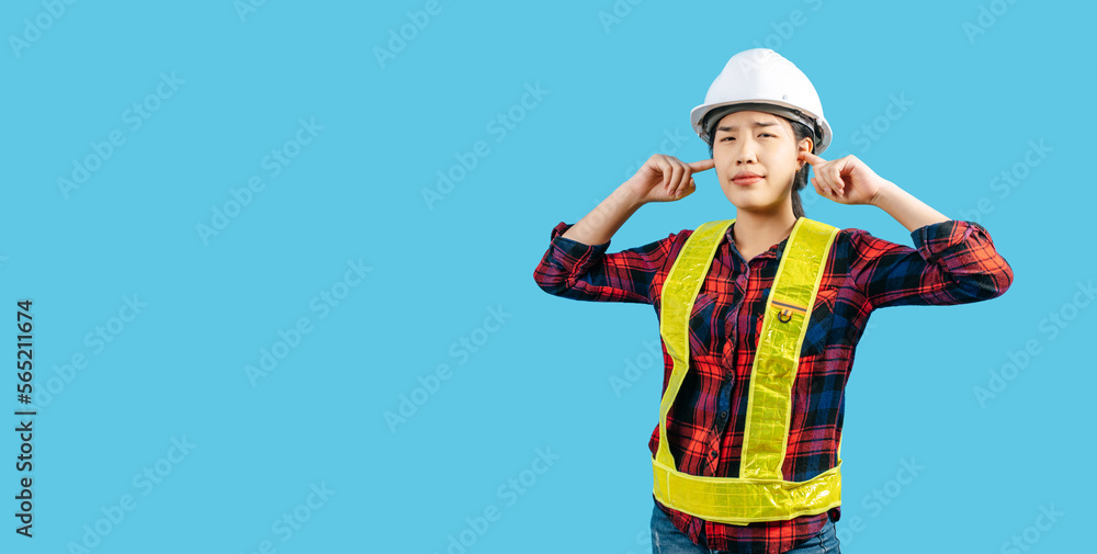 Young asian engineer female wearing helmet use finger plug her ears Young asian engineer female wearing helmet use finger plug her ears