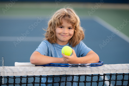 Tennis kids. Tennis is my favorite play. Portrait of a pretty sporty child with a tennis racket. Little kid smiling tennis court. Training and sport for kid. © Volodymyr