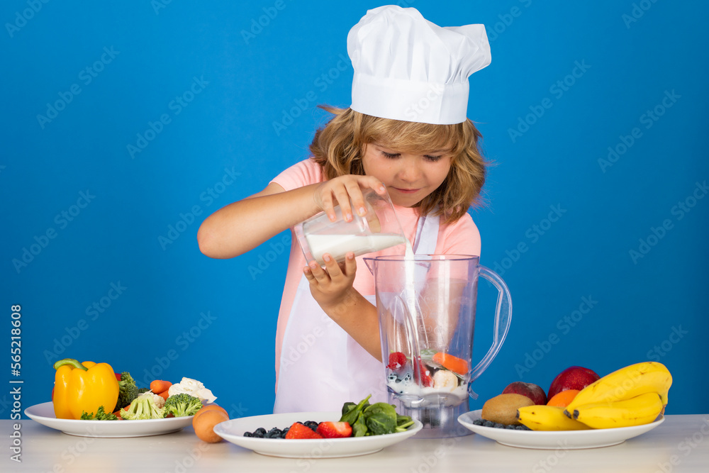 Child chef dressed cook baker apron and chef hat cooking milk shake smoothie isolated on studio background. Healthy nutrition kids food. Child chef dressed cook baker apron and chef hat cooking milk shake smoothie isolated on studio background. Healthy nutrition kids food.