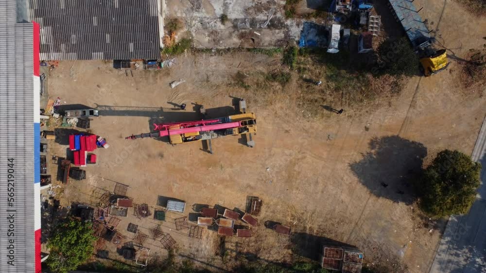 Mobile crane stands waiting to lift steel at a warehouse. Crane