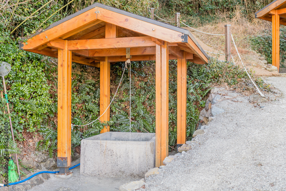 Water well under wooded pavilion beside hiking trail in mountain park. Water well under wooded pavilion beside hiking trail in mountain park.