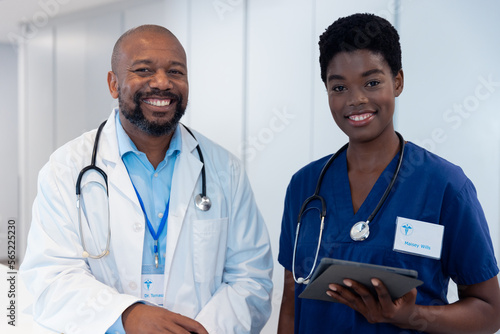 Portrait of smiling african american male and female doctor in hospital corridor