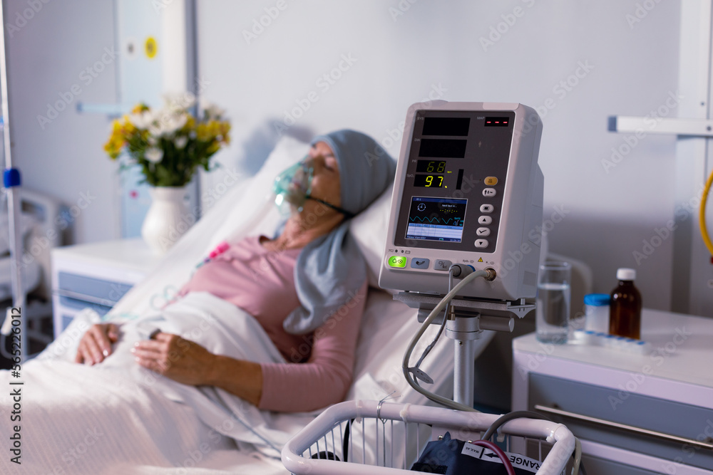 Senior caucasian female cancer patient wearing head scarf in bed with oxygen mask at hospital Senior caucasian female cancer patient wearing head scarf in bed with oxygen mask at hospital
