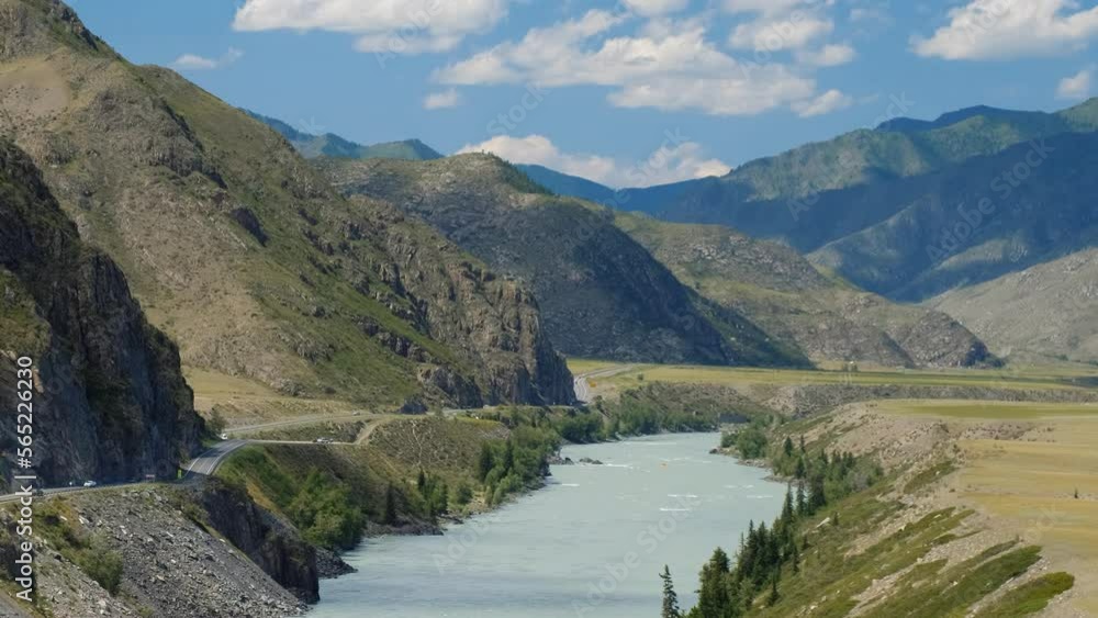 Video of Altai natural landscape with river Katun under blue sky with clouds. On the left bank of the river there is Chuya Highway. Video of Altai natural landscape with river Katun under blue sky with clouds. On the left bank of the river there is Chuya Highway.