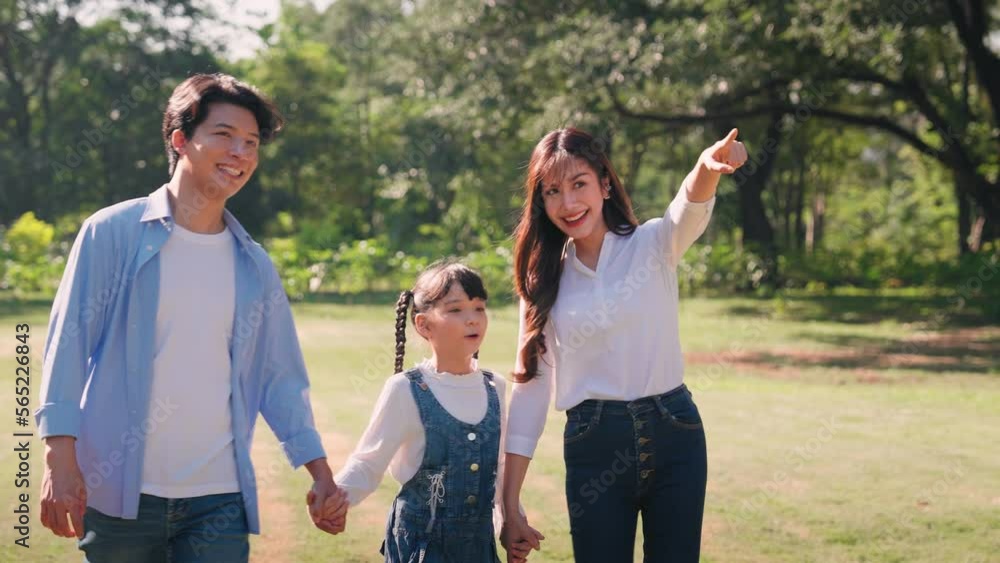 Happy Asian family walking in the public park, Outdoor with family togetherness concept Happy Asian family walking in the public park, Outdoor with family togetherness concept