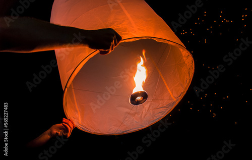 Person holding paper lantern during Yi Peng festival, Chiang Mai, Thailand