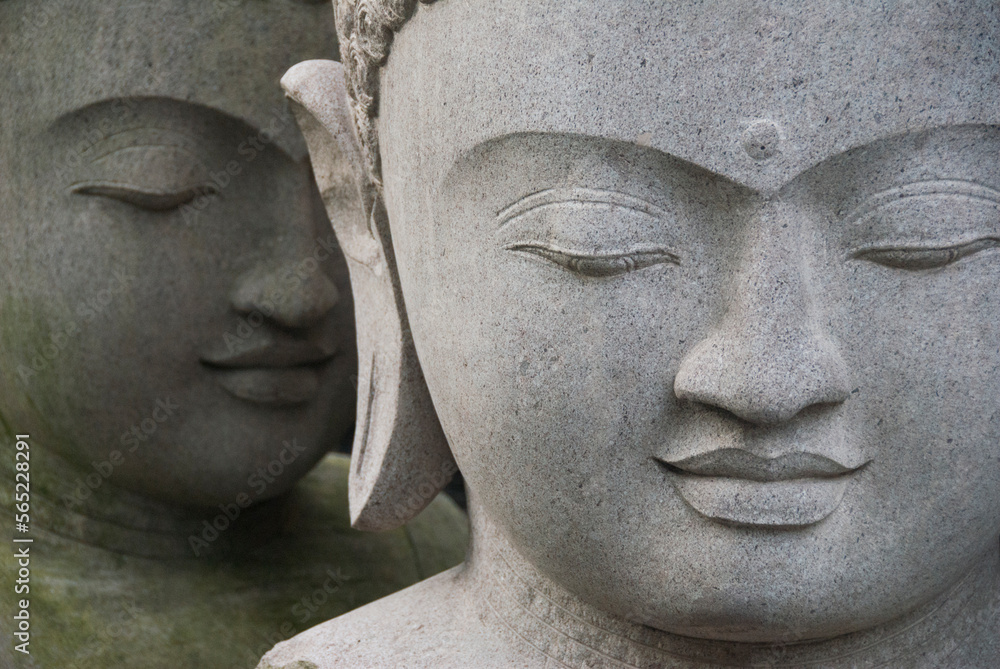 Two buddha statues juxtaposed as if one is whispering to the other, Ubud, Bali Two buddha statues juxtaposed as if one is whispering to the other, Ubud, Bali