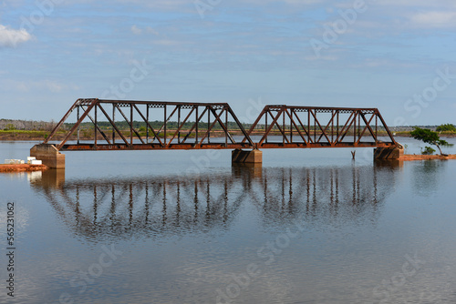 An old metal bridge on the historic, abandoned Madeira-Mamoré Railroad, surrounded by plains flooded due to the construction of the Jirau Dam, between Guajará-Mirim and Porto Velho, Rondonia, Brazil
