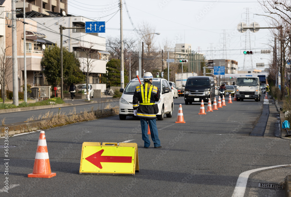 Foto de 道路工事のため車を誘導する交通誘導員 do Stock Adobe Stock