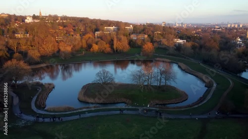 Beautiful drone shot people walking in urban park with pond in England photo