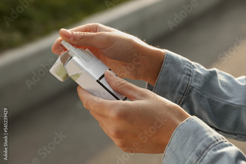 Woman taking cigarette out of pack outdoors  closeup
