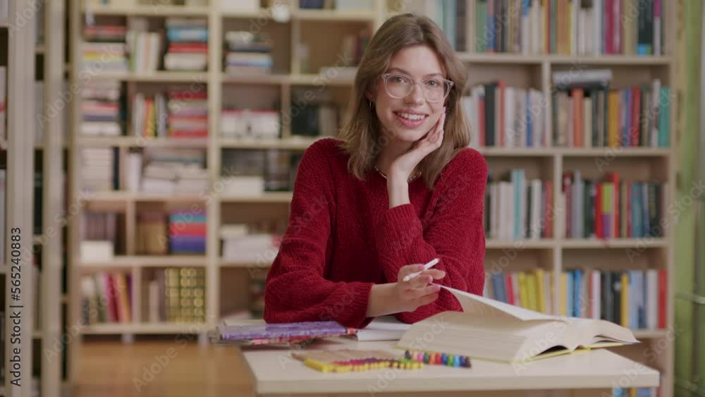Medium shot of smiling caucasian girl studying at library, slomo Medium shot of smiling caucasian girl studying at library, slomo