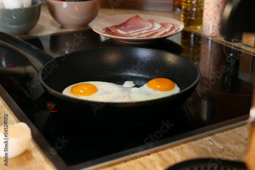 Frying eggs in kitchen for tasty breakfast