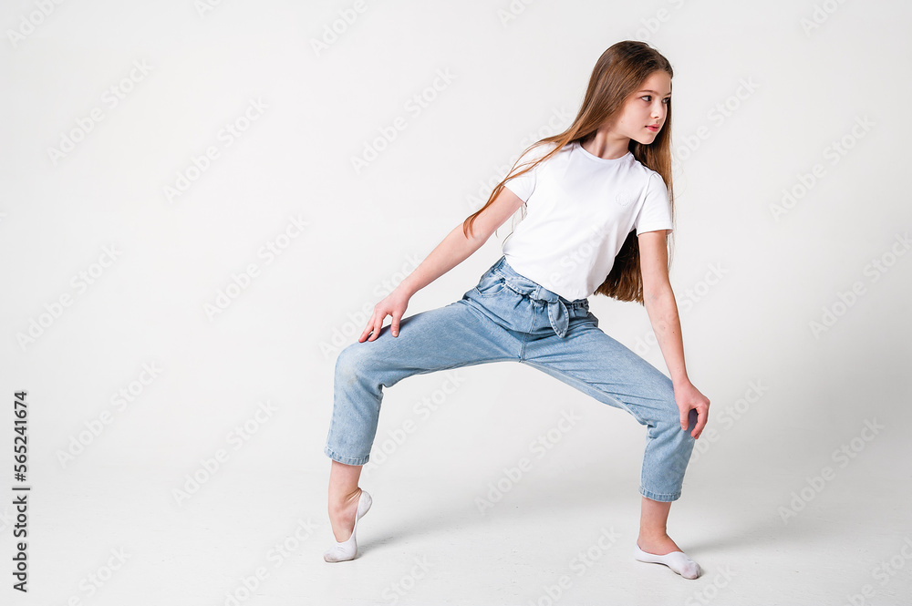 A teenage girl in jeans and a white T-shirt performs dance moves. White background A teenage girl in jeans and a white T-shirt performs dance moves. White background