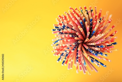 Many paper drinking straws on yellow background, top view. Space for text