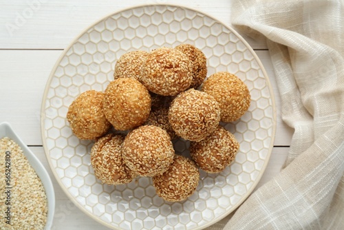 Delicious sesame balls on white wooden table, flat lay