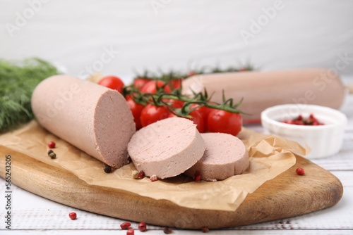 Delicious liver sausages and other products on white wooden table