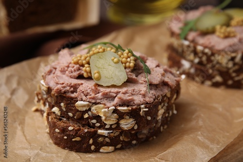 Delicious liverwurst sandwiches with pickled cucumber and mustard on table  closeup