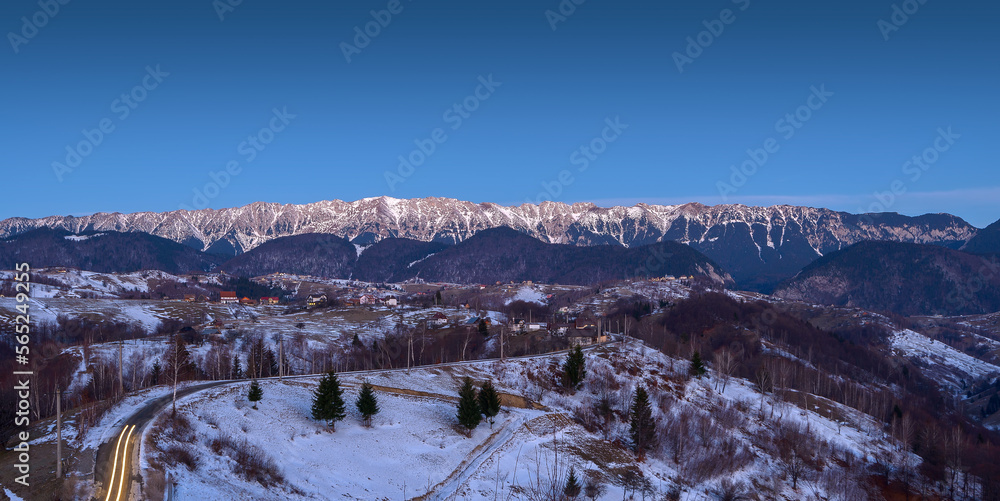 Panoramic winter view of Piatra Craiului National Park, mountain range in the Southern Carpathians in Romania. Hiking above the clouds. Majestic nature scenery with snowy mountains in background