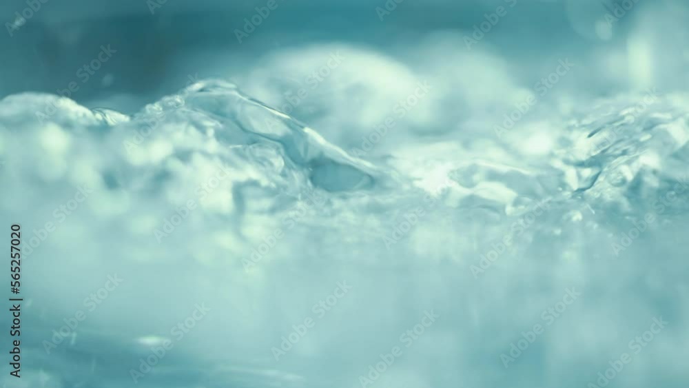 A mountain river with crystal clear water. Well water is flowing over stones. Abundant blue stream in a forest. Cold water splashing near rapids. Concept of mineral water. Super slow motion shot