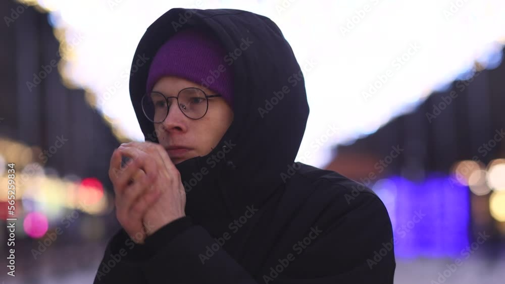 Handsome Man in trendy Eyeglasses and Winter Coat in Snowy city warms his hands. Winter Concept. Handsome Man in trendy Eyeglasses and Winter Coat in Snowy city warms his hands. Winter Concept.