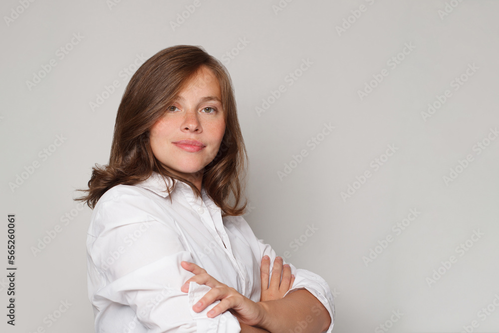 Confident pretty female doctor brunette woman smiling and looking at camera against white studio wall background Confident pretty female doctor brunette woman smiling and looking at camera against white studio wall background
