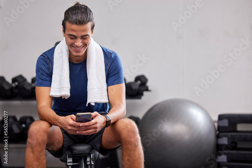 Fitness, phone or man on social media to relax at gym in training, workout or exercise resting on a break. Tired, happy or healthy sports athlete typing text on a bench and exercising for body goals