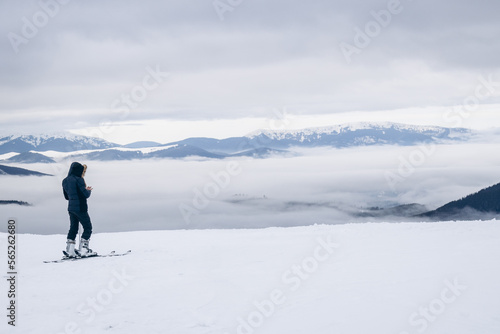 The skier rides high in the snow in the mountains. Fog on the mountain and people skiing
