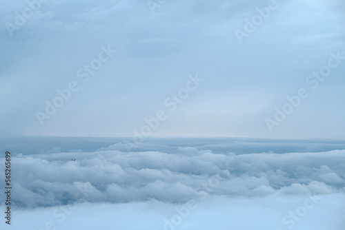 Cloudy sky with more cloud and very small plane compose on skyline