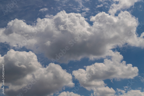 White cumulus clouds on a clear blue sky.
