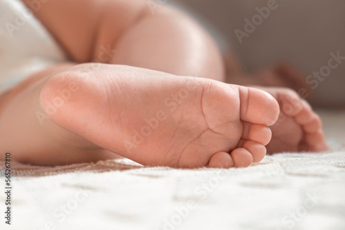 Tiny Babies Feet on White Knitted Blanket. Close up of Small Bare Foot of Infant Sleeping on Soft Bed. Cute Newborn Baby Toes. Concept of Childhood, Maternity, Health. Sleep Newborn Child. Skin care © Marina Demidiuk