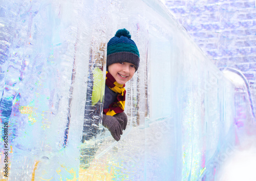 Snow and Ice Festival. a happy child is standing on an ice train