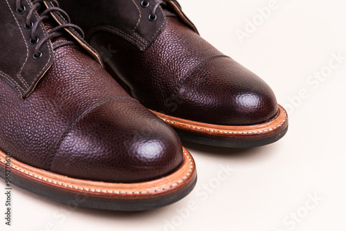 Closeup of Toes of Premium Dark Brown Grain Brogue Derby Boots Made of Calf Leather with Rubber Sole Placed Over Beige