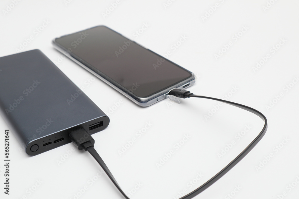 Power bank and smartphone on white background. Modern technology concept. Power bank and smartphone on white background. Modern technology concept.