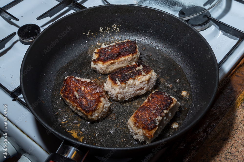 Turkey cutlets fried on one side lie in oil in a frying pan Turkey cutlets fried on one side lie in oil in a frying pan