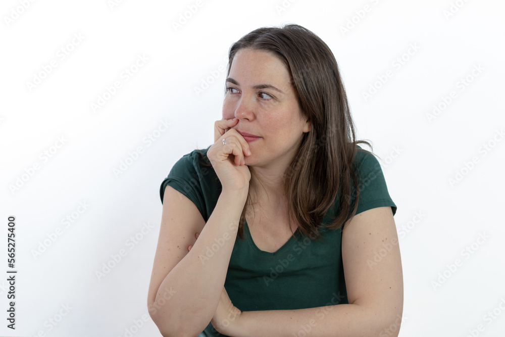 pensive woman looking at the ground with her hand on her face pensive woman looking at the ground with her hand on her face