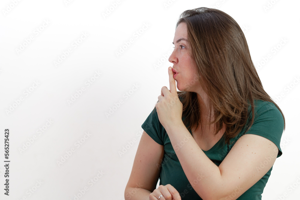 woman in profile with finger in mouth asking for silence woman in profile with finger in mouth asking for silence