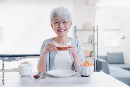 Plakat w ramie 笑顔で朝食を食べるシニアの女性