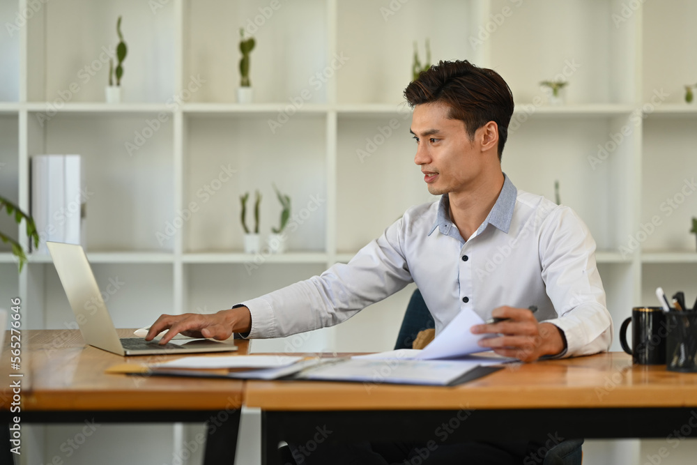 Successful businessman using laptop, working on financial and marketing project at contemporary office Successful businessman using laptop, working on financial and marketing project at contemporary office