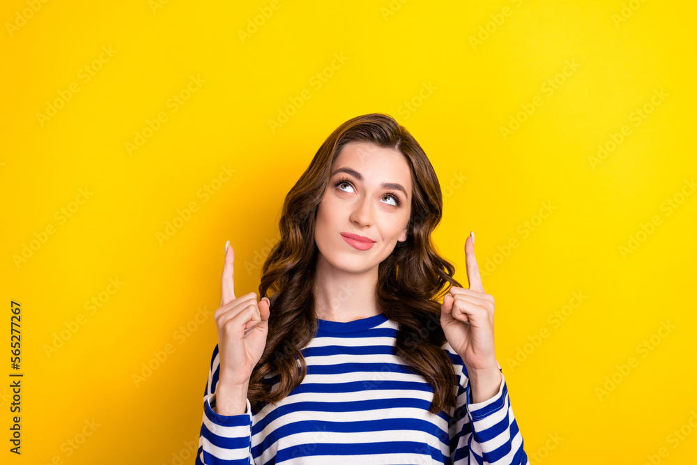 Photo of young wavy brown hair lady striped pullover looking minded direct fingers up mockup choosing best option isolated on yellow color background Photo of young wavy brown hair lady striped pullover looking minded direct fingers up mockup choosing best option isolated on yellow color background