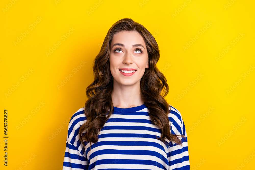 Photo of thoughtful shiny young girl dressed striped pullover looking up empty space isolated yellow color background Photo of thoughtful shiny young girl dressed striped pullover looking up empty space isolated yellow color background