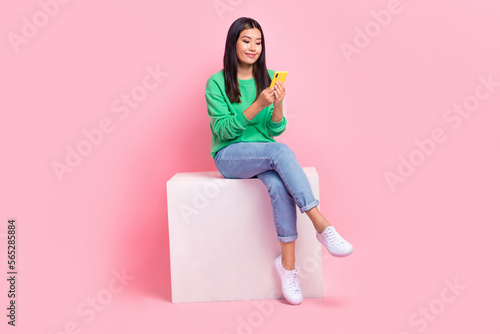 Full length portrait of gorgeous lovely person sit podium hold use telephone isolated on pink color background