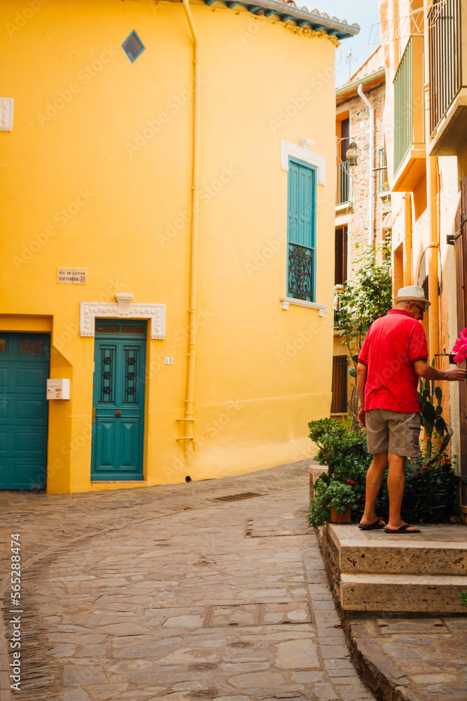 Une rue colorée de Collioure. Un touriste à Collioure. Des façades de couleurs dans le sud de la France. Tourisme en méditerranée.