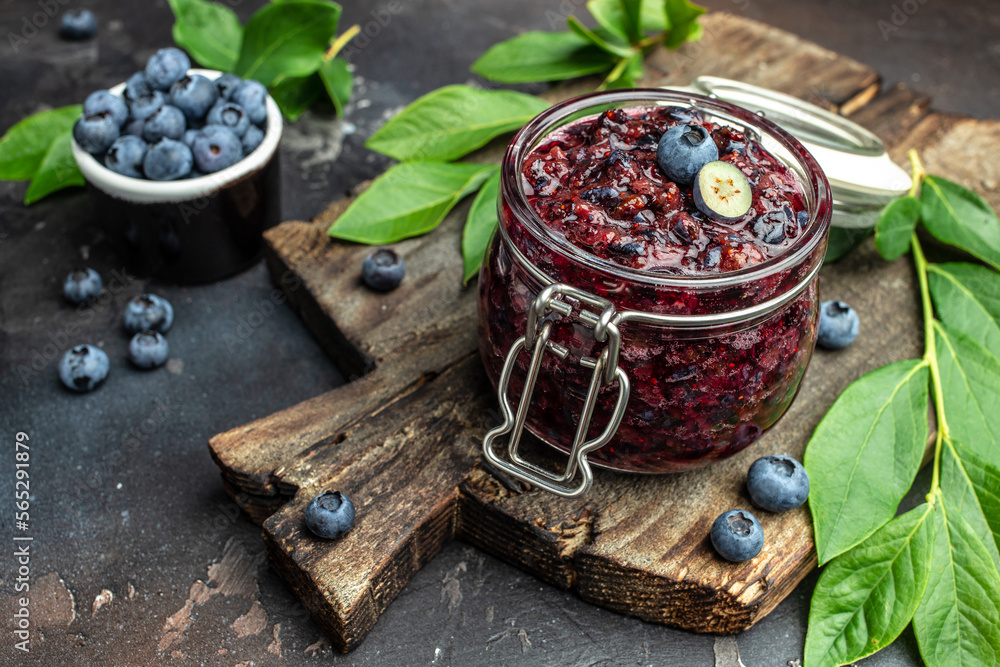 homemade blueberry jam in a jar and fresh blueberries. place for text, top view homemade blueberry jam in a jar and fresh blueberries. place for text, top view