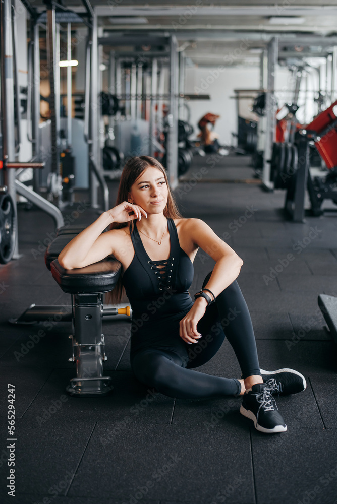 Pleasant woman in sportswear resting after training at gym