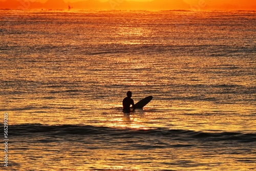Surfers on the beach at dawn in winter. © tamu