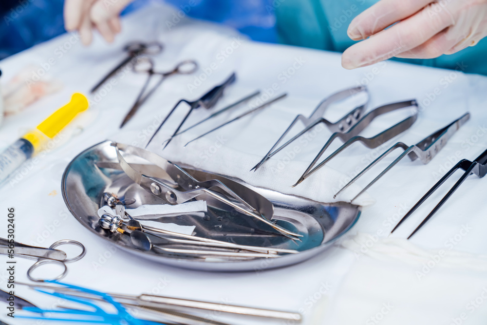 Medical tools on blur surgery background. Bowl with sterile scissors in the operating room. Close-up. Instruments for surgical procedure.