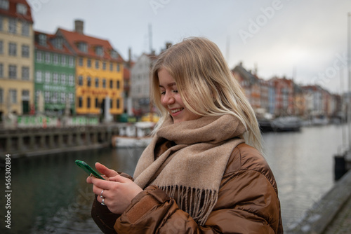 Canvas Print A contented girl uses her smartphone while in downtown Copenhagen